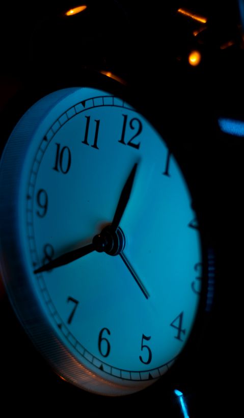 Stop the clock? – Verantwortung kennt keine Anwendungsschwellenwerte Ein analoger Wecker mit dunklem Hintergrund